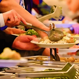 Gäste bedienen sich am warmen Buffet mit verschiedenen Speisen – privates Catering von Tafelfreuden Köln